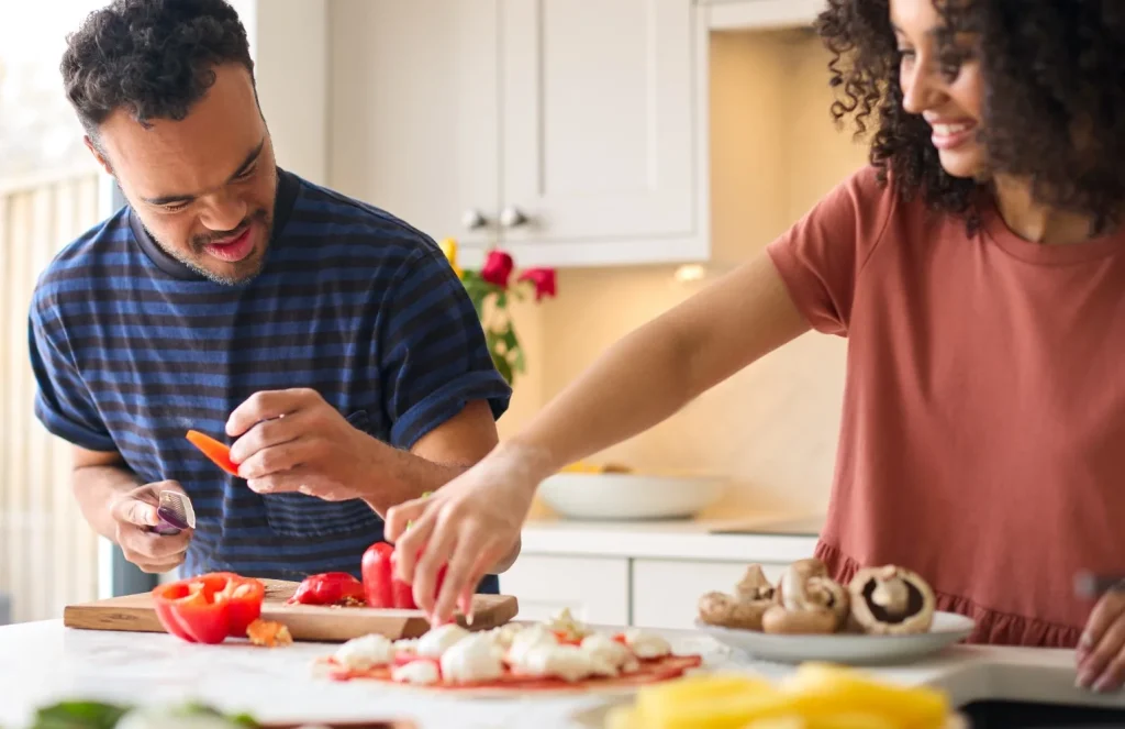 Disabled man making meal with support worker