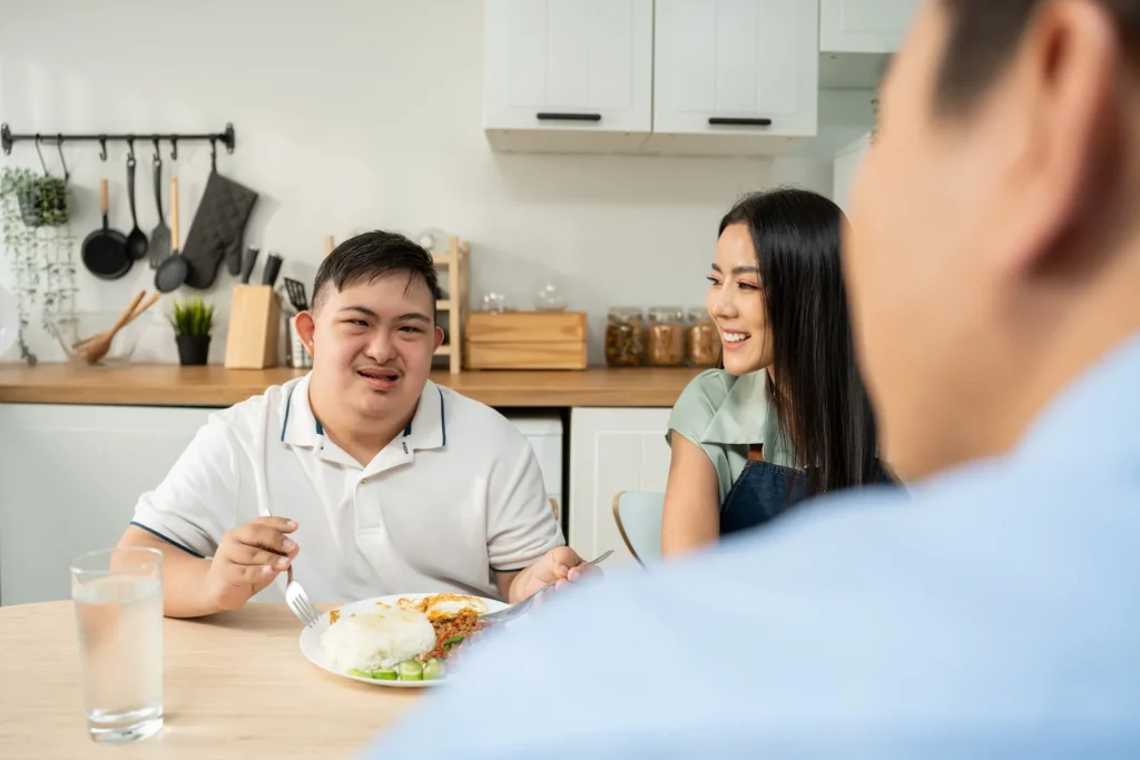 Disabled man having meal with support workers