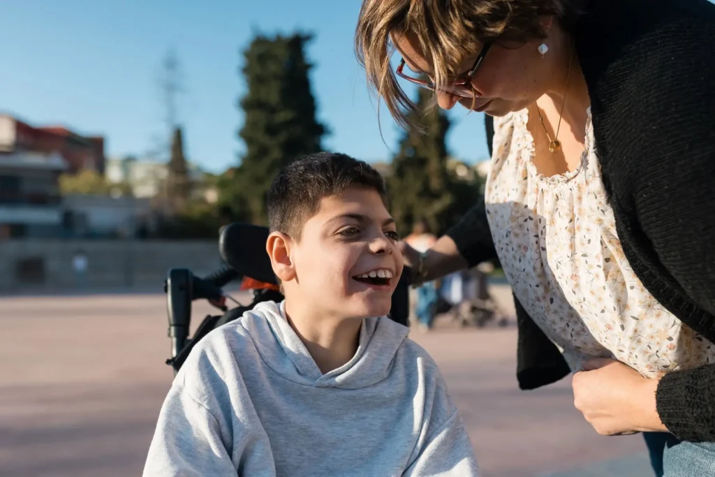 Disabled boy in wheelchair with carer